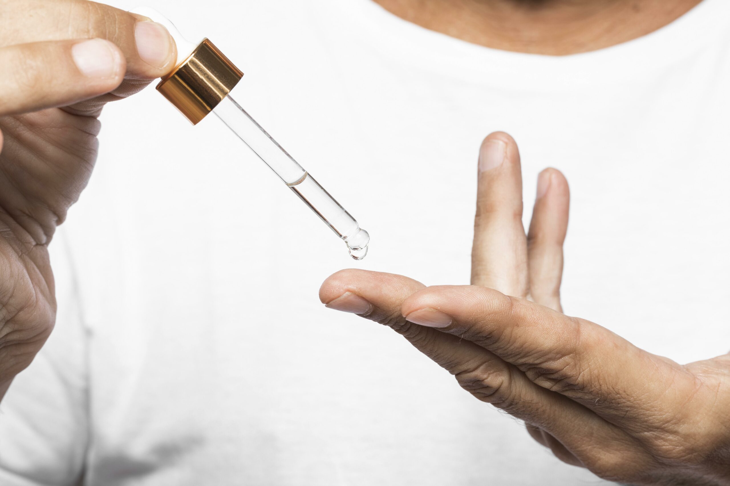 close-up-hands-holding-serum-pipette